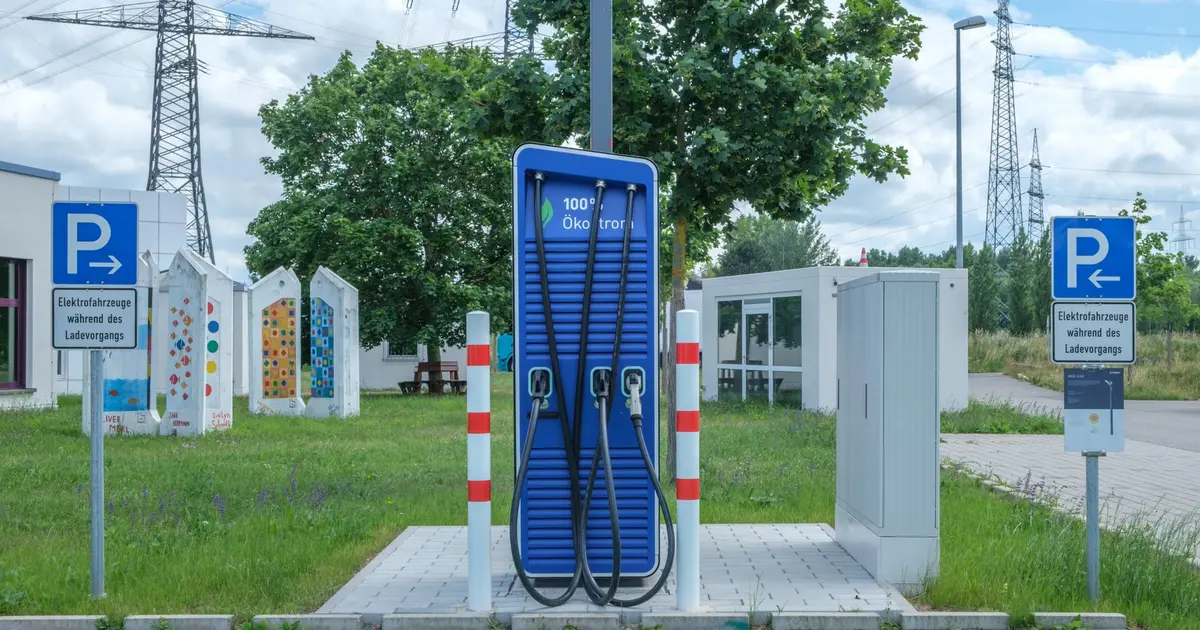 Electric car check: EV charging at a public charging point with road tax and MOT history check on screen